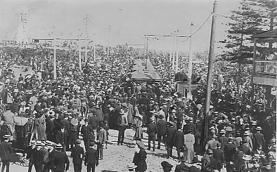 Crowds departing after arrival of American fleet August 1908. Lighthouse at extreme left. Trams are saturated with passengers.